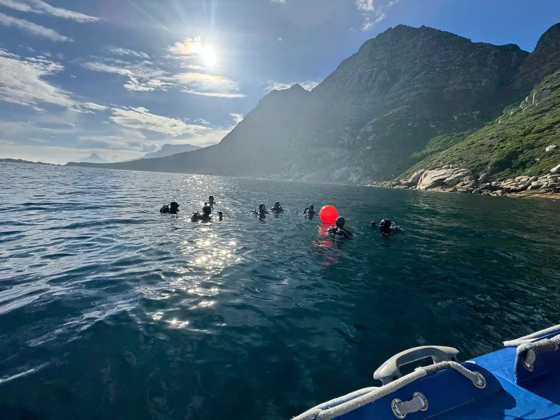 Divers on the surface beneath Cape Town's Atlantic mountains
